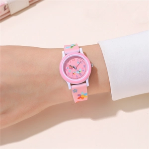Détail d'une montre quartz rose pour enfant avec motifs papillons et fleurs sur le bracelet