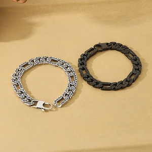 Detail of vintage engraved Cuban link bracelet in silver and black matte finishes