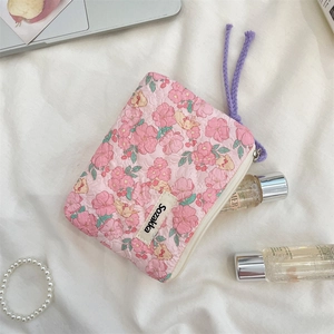 Detailed view of floral quilted cotton pouch with purple drawstring and zipper closure