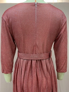 Gros plan du tissu plissé métallisé rose avec fermeture invisible et ceinture assortie