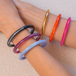 Ensemble de bracelets minimalistes en résine acrylique colorée portés par un mannequin