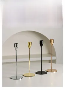 Detail of elegant aluminum candle holders in four metallic finishes on white table
