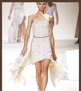Detailed view of an elegant white embroidered strapless dress with a thin metal waist chain