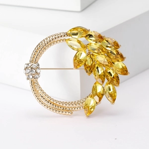 Elegant golden wheat ear brooch with yellow crystals and white diamonds on white background