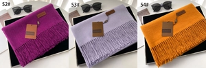 Close-up of thick winter tassels on solid color warm scarves in multiple color options
