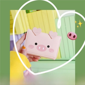 Detailed view of pink cartoon pig short wallet held in hand with cute 3D ear stitching