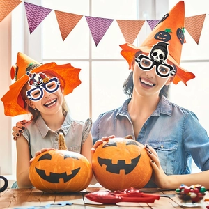 Halloween party set with funny skull glasses and orange wizard hats for festive costumes