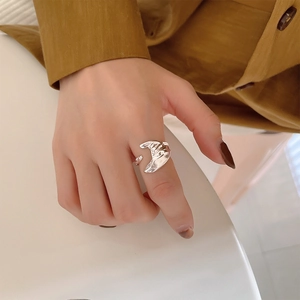 Close-up of irregular liquid-style S925 silver open ring worn on a finger