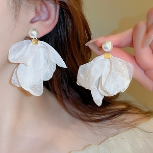 Close-up of white organza mesh flower earrings with pearls and golden metal clasps