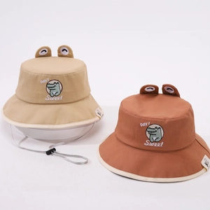 Détail de chapeaux de soleil bébé avec broderie crocodile et cordons coupe-vent ajustables