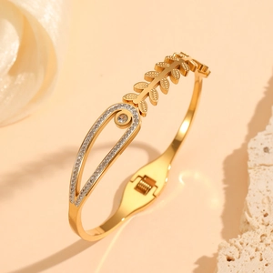 Détail d'un bracelet doré en arête de poisson avec gouttes évidées et diamants blancs