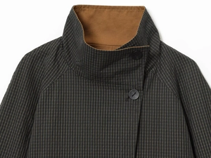 Close-up of stand-up collar with dark plaid pattern and contrasting caramel lining