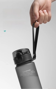 Close-up of matte grey sports bottle featuring nylon strap and secure locking lid