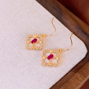 Vintage gold plated flower earrings with red zircon and white shell on a textured base