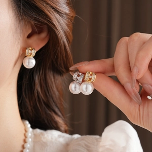 Detail of vintage pearl letter stud earrings with gold plating and sparkling crystals