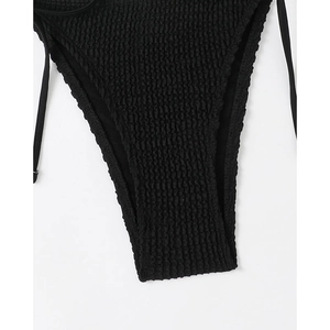 Close-up of black crinkle fabric bikini bottom with side ties and smocked texture