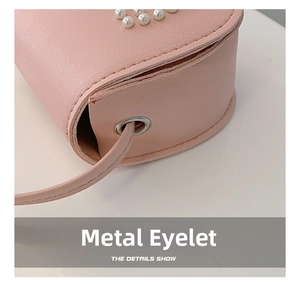 Detailed side view of pink girls' mini bag with pearl decor and metal hardware