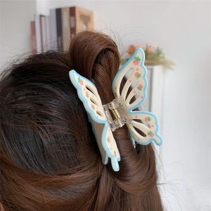 Close-up of butterfly hair claw clip with floral pattern on model's hair