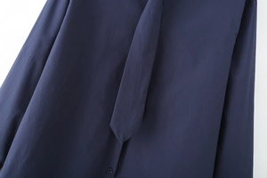 Detail view of the fine cotton poplin fabric and matching tie on the navy blue shirt