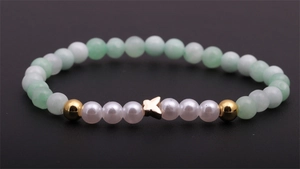 Bracelet tendance en perles de cristal vert et nacre avec un pendentif papillon doré