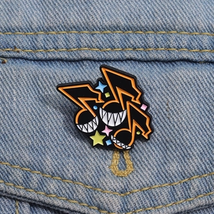 Broche émaillée note de musique avec yeux étoilés sur veste en jean bleue
