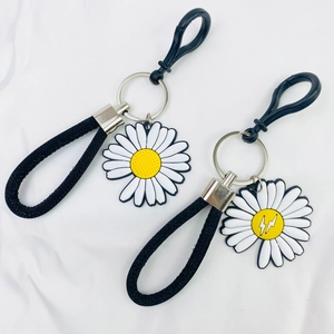 Detailed view of daisy keychains with floral charms and woven black wrist straps