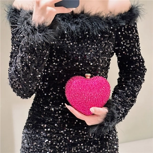 Close-up of heart-shaped mini evening bag with vibrant pink rhinestones and metal clasp