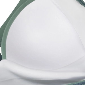 Detail view of the padded white swim cup with seamless green fabric edging and stitching