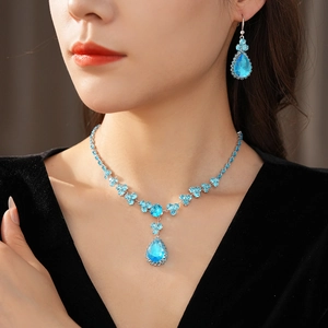 Dettaglio della collana e degli orecchini eleganti con zircone blu a goccia sul modello