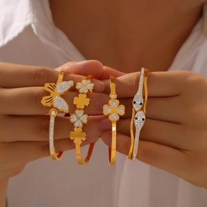 Elegant gold titanium butterfly and clover bangles featuring sparkling zircon stones