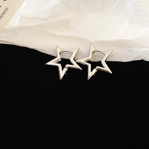 Detailed close-up of silver star-shaped hollow earrings on a premium black velvet surface