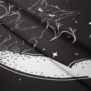 Detail of bohemian black cat tapestry showing high contrast moon and star fabric patterns