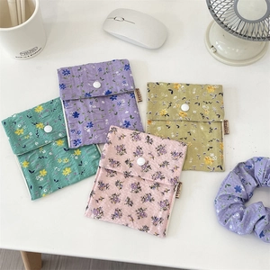 Detailed view of floral sanitary napkin pouches with snap button and matching hair scrunchie