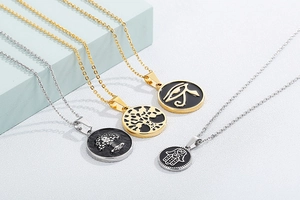 Detailed macro view of four round gold and silver Tree of Life pendants with black enamel