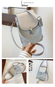 Detail view of a silver crossbody phone bag featuring crinkled metallic texture and metal lock