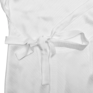 Detailed macro view of white textured fabric with a waist tie-up bow design