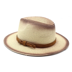 Detailed view of woven straw fedora featuring a brown suede band and gold buckle detail