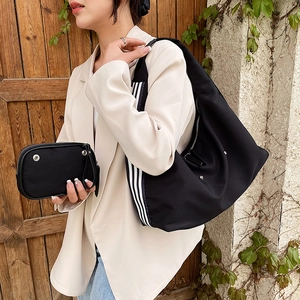 Fashionable black nylon crescent shoulder bag with striped strap and matching pouch