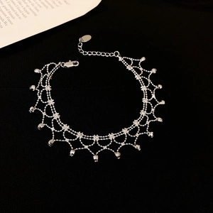 Detailed view of layered silver lace fringe bracelet with beaded charms on black background