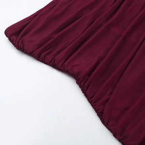 Détail d'une robe en résille bordeaux montrant des bords plissés et une texture tricotée