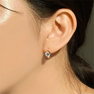 Close-up of minimalist gold plated 925 sterling silver stud earring with cubic zirconia