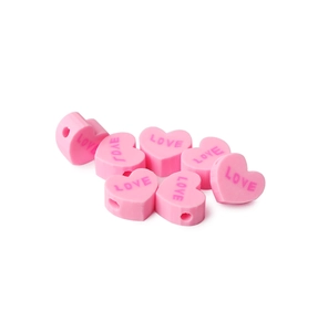Close-up of pink heart-shaped clay beads with 'LOVE' text for DIY jewelry making