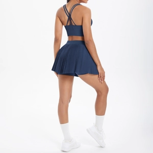 Détail d'un soutien-gorge de sport dos croisé bleu marine et jupe de sport plissée