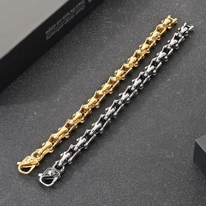 Detail of punk skull clasp and bone-shaped link chain in gold and silver steel finish