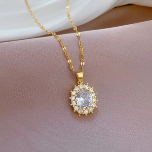 Detailed close-up of a luxury gold necklace featuring an oval-shaped crystal pendant