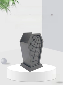 Detailed view of black coffin makeup brush holder with spider web relief and sturdy base