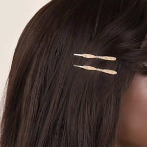 Elegant gold streamline hair clips with rhinestones on deep brown hair, bridal hair accessories