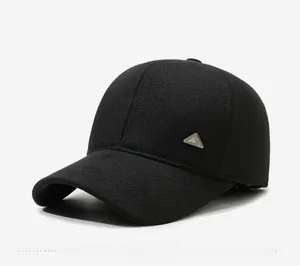 Detail view of black textured baseball cap with metallic logo and ear protection padding