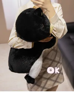 Gros plan d'une personne tenant une grande peluche pingouin en fausse fourrure douce