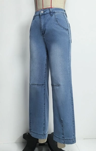 Détail du jean taille haute bleu clair avec coutures genoux et fente latérale